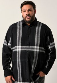 Černá a šedá kostkovaná košile na knoflíky vyrobená z flanelu, s klasickým límcem a dlouhými rukávy s volným střihem.