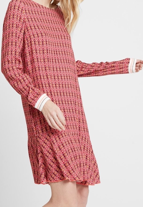 Robe rouge à motif en losange, manches longues avec poignets blancs, coupe décontractée et longueur au-dessus des genoux.