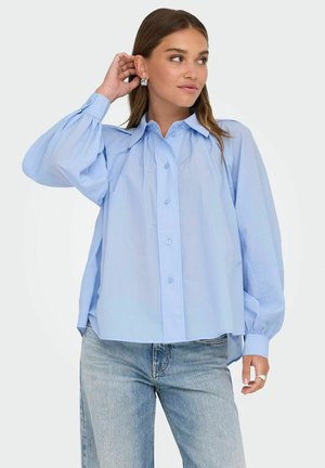 Lichtblauw overhemd met een relaxed fit, voorzien van lange, puffed mouwen en een puntige kraag. Gemaakt van gladde stof.