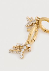 Zlaté kruhové náušnice s visiacimi príveskami v tvare písmen A a Y, zdobené priehľadnými rhinestonmi na bielom pozadí.