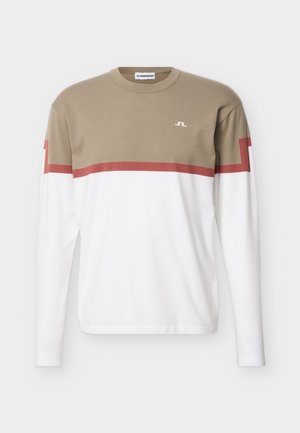 Maglietta a maniche lunghe con scollo rotondo, sezione superiore beige, sezione inferiore bianca e dettagli con strisce rosse su petto e maniche, piccolo logo sul petto.