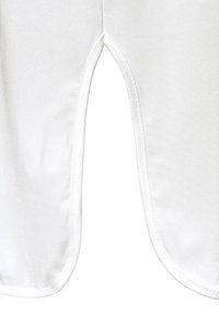 Weißes Kleidungsstück aus glattem Stoff mit leichtem Glanz, Ausschnittdesign in der Mitte und sauberer Naht entlang der Kanten.