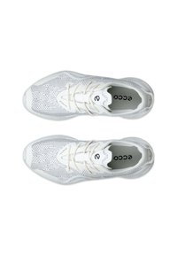 Bílé sportovní boty s vrchní vrstvou ze síťoviny, která má bodový vzor, šněrovací design a polstrovaný límec. Logo je viditelné na stélce.