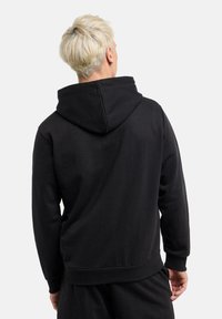 Black hoodie made from soft material, featuring a large hood, ribbed cuffs, and waistband. Simple design with no visible logos or patterns.