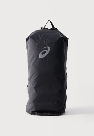 Kõrge must spordikotiga topistangiga ja esiküljel peegeldava ASICS logo tavalise valge tausta ees.