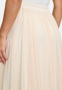 Gonna in tulle rosa chiaro con strati di tessuto trasparente, finitura morbida e testurizzata, e vita elasticizzata per un indosso confortevole.