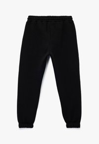 Pantalones jogger de forro polar negro con cintura elástica y puños en los tobillos, extendidos sobre un fondo blanco.