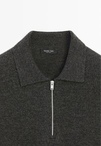 Maglione a girocollo grigio scuro con chiusura frontale con cerniera, collo pieghevole e texture morbida. Presenta un'etichetta con la scritta "Massimo Dutti".