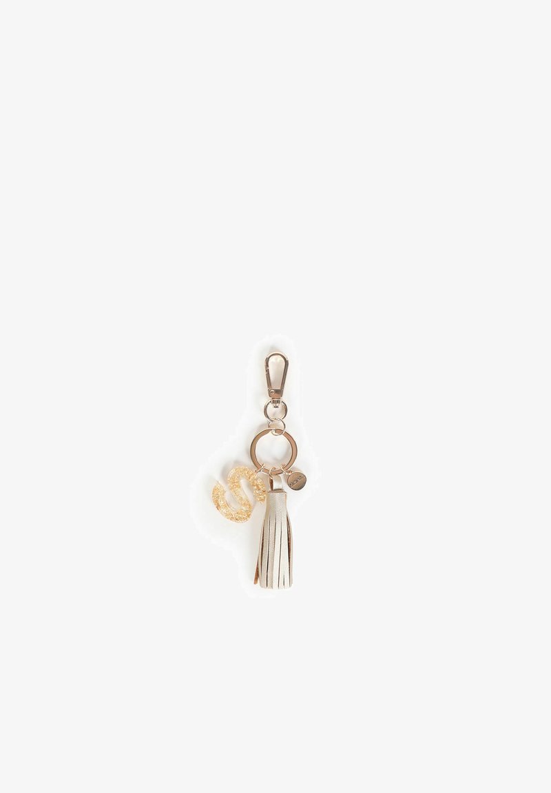 Porte-clés avec un gland en argent, un charme en forme de S étincelant doré et un anneau en métal pour la fixation. Textures lisses avec une finition brillante.