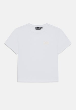 Balta īsajām piedurknēm kreklu ar apaļu kakla izgriezumu, kurā uz kreisā krūšu ir neliels zelta EA7 Emporio Armani logo un melna zīmola etiketē iekšējā kakla daļā.