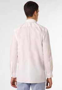 Witte langemouwshirt met een klassieke kraag en knoopmanchetten, voorzien van een gladde stof en een getailleerde pasvorm.