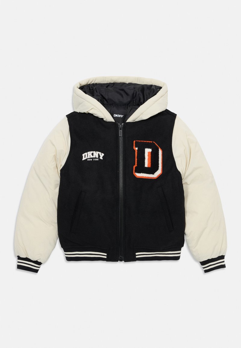 Giacca con cappuccio nera e crema, con zip frontale, caratterizzata da un grande ricamo della "D," logo DKNY e polsini a coste a righe. Texture morbida.