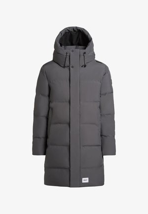 Abrigo de plumas gris con capucha, que presenta un cierre frontal de cremallera, botones a presión, diseño acolchado y cordón ajustable. Etiqueta en la parte inferior izquierda.