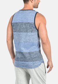 Blå og grå stribet tanktop med rund halsudskæring og et afslappet design. Stoffet har en blød tekstur og en løs pasform.