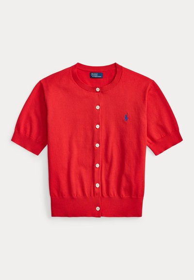 Piros, rövid ujjú, gombos kardigán bordázott alsó résszel és mandzsettával, bal oldali mellrészen kis kék hímzett logóval.