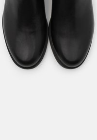 Black leather ankle boots with a rounded toe, smooth finish, and minimalistic design, featuring a low-profile rubber sole.