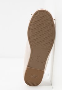 Semelle plate beige de chaussure avec motif de grip texturé, marque "Tamaris", taille 37, et texte "ANTI-SLIDE" sur le talon.