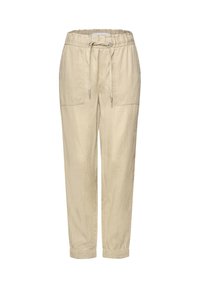 Pantalon beige décontracté avec ceinture élastiquée, cordon, grandes poches avant et poignets élastiques aux chevilles.
