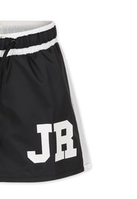 Shorts sportivi in bianco e nero realizzati in un tessuto leggero. Presentano un elastico in vita con cordino e una grande grafica "JR".