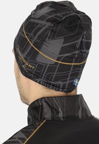 Zwarte sportbeanie met een geometrisch patroon, met grijze lijnen en een gouden accent. Inclusief een klein detail van de blauwe en gele Zweedse vlag.