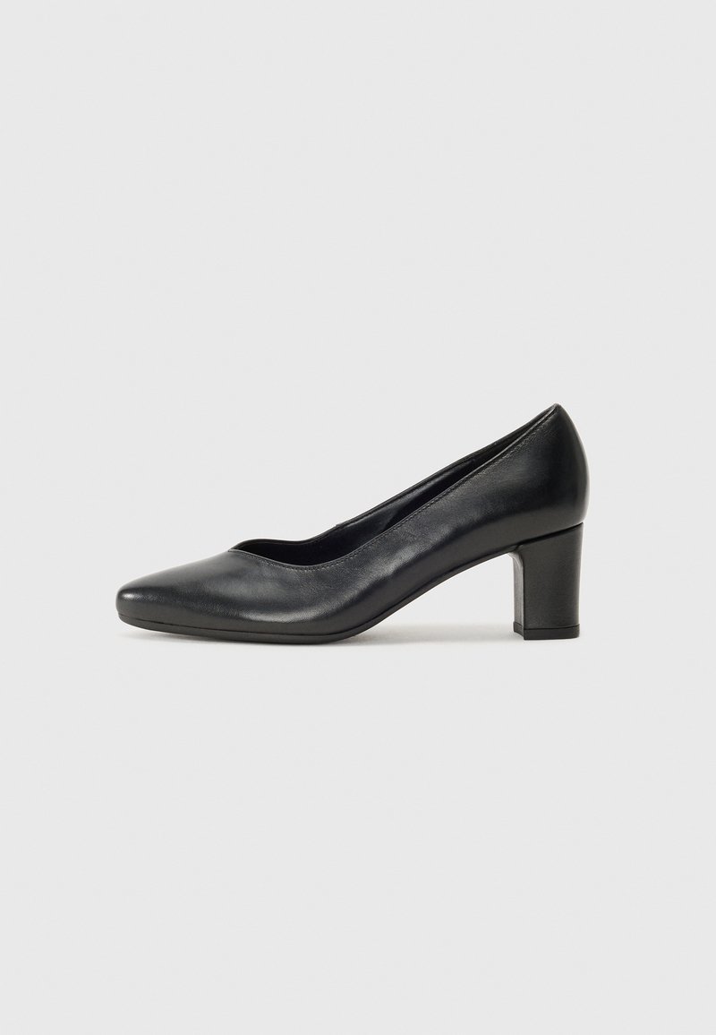 Escarpin en cuir noir à talon moyen, bout rond et talon carré sur un fond gris clair uni.