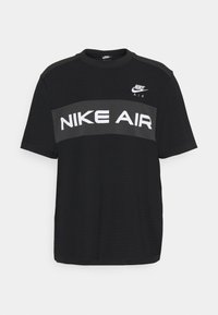 Svart kortärmad T-shirt i mesh-material. Har ett grått horisontellt rand med "NIKE AIR" i fetstil vita bokstäver och en logotyp vid halslinningen.