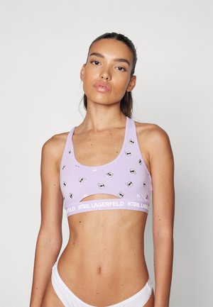 Lila sport-bh met uitgesneden ontwerp, voorzien van witte patronen en een witte "KARL LAGERFELD" tailleband. Gladde stofstructuur.