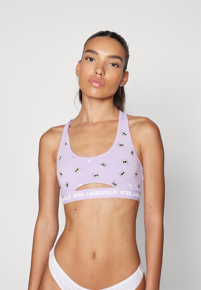 Top sportivo lilla con design a taglio, caratterizzato da dettagli bianchi a motivo e una fascia bianca "KARL LAGERFELD". Tessuto dalla consistenza morbida.