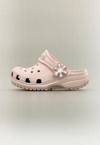 Ανοιχτό ροζ clog με τρύπες αερισμού, υφή στη σόλα και ρυθμιζόμενο λουράκι με διακοσμητικό κουμπί σε σχήμα λουλουδιού.