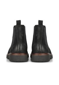 Botas de cuero negro hasta el tobillo con paneles elásticos en los laterales, punteras redondeadas y suelas de goma gruesas. Presenta un acabado texturizado sutil y acentos en marrón.