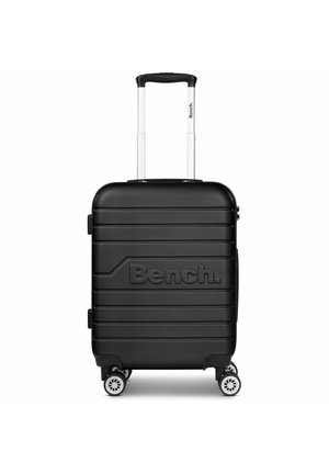 Black hard-shell suitcase with ridged exterior, embossed "Bench." logo, retractable handle, and four wheels.