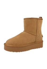 Stivaletto alla caviglia in camoscio color cammello con punta arrotondata, cucitura laterale e suola in gomma texturizzata. Design leggero con linguetta posteriore per facilitarne la calzata.