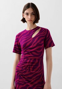 Strak pakt met een paarse en rode zebra-print, korte mouwen, een zijcut-out detail en geplooide textuur langs de taille.
