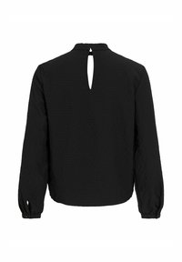 Svart bluse med lange ermer i teksturert stoff, nøkkelhullåpning bak og mansjetter med knapper. Enkel, løs passform.