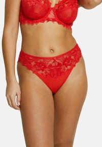 Ensemble de lingerie en dentelle rouge comprenant un soutien-gorge à motifs floraux et une culotte avec un ourlet en dentelle assorti. Tissu doux et détails délicats.