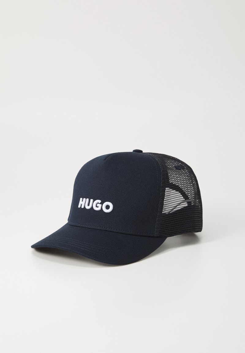 Boné de basebol azul-marinho com frente sólida e parte de trás em malha, com "HUGO" bordado em branco na frente. Visor curvo e tira ajustável.