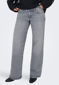 Γκρι τζιν με φαρδιά μπατζάκια από απαλό υλικό denim, με μέση στο μέσο ύψος, σχεδιασμό με πέντε τσέπες και διακριτικό ξεβάμμα στα πόδια.