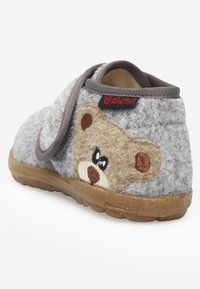Szare klapki z motywem niedźwiedzia, z miękkiego filcu, o zaokrąglonym kształcie, gumowej podeszwie i elastycznym pasku ułatwiającym zakładanie.