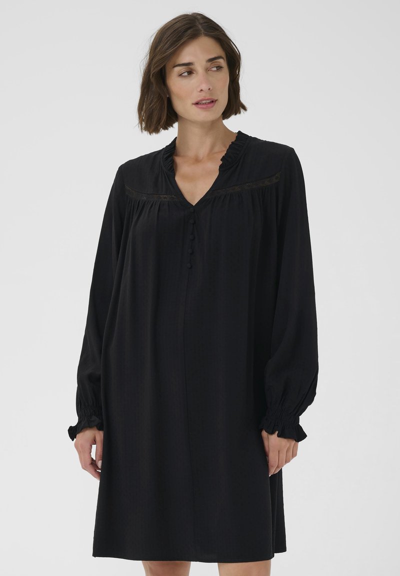 Schwarzes Kleid mit langen, gepufften Ärmeln und einem gerafften Ausschnitt. Verfügt über dekorative Knöpfe und Spitzenverzierungen am Oberteil. Glatte Textur.