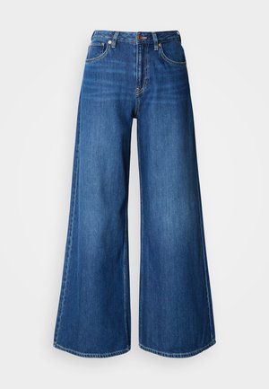 Jeans blu a gamba larga in denim. Presentano una vita alta, linee pulite e cuciture a contrasto. Le gambe si allargano significativamente all'orlo.