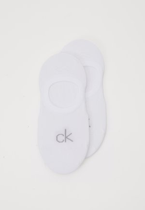 Bele nogavice, narejene iz mehkega bombažnega blaga, bele barve, z okrožnim krojem in sivim logotipom "ck" na strani za diskretno blagovno znamko.