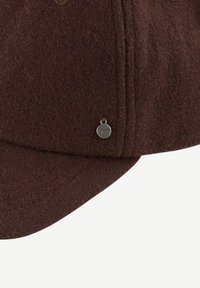 Chapeau en feutre marron avec une visière courbée, présentant une couture et un petit logo métallique sur le côté.