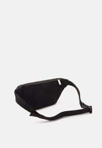 Marsupio nero realizzato in materiale testurizzato con una chiusura zip nella parte superiore, dotato di una larga cintura regolabile e di una forma contornata imbottita.
