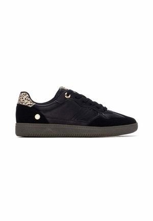 Zapatilla negra de caña baja con lengüeta en el talón de estampado de leopardo, ojal dorado y pequeño logo redondo dorado en el lateral, y suela gris texturizada.