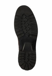 Semelle en caoutchouc noir avec des motifs texturés, y compris des formes de diamant et des rainures pour l'adhérence. La conception présente une construction durable et robuste.