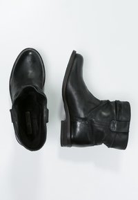 Botas de tobillo de cuero negro con punta redonda, tacón bajo y apilado, y detalles fruncidos en el caña. Textura suave con hardware mínimo.