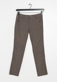 Pantalons slim-fit marron avec poches avant et détails de boutons suspendus sur un cintre noir contre un fond blanc.