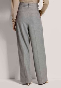 Graue, maßgeschneiderte Hose mit weit geschnittenem Design, hoher Taille und subtiler Textur. Verfügt über Gesäßtaschen und eine saubere, polierte Optik.