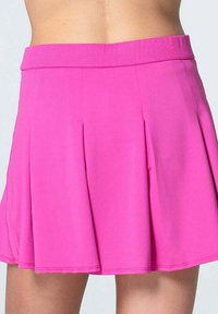 Falda plisada rosa con cinturilla acanalada, hecha de tela suave. Presenta una forma acampanada y una textura suave, adecuada para el uso diario.