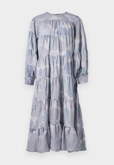 Zila kārtota kleita, izgatavota no mīkstas auduma. Tam ir apaļa izgriezuma, garas piedurknes ar savilktiem galiem un plūstoša volāna apakšdaļa.